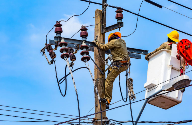 Utility workers working on a transmission pole