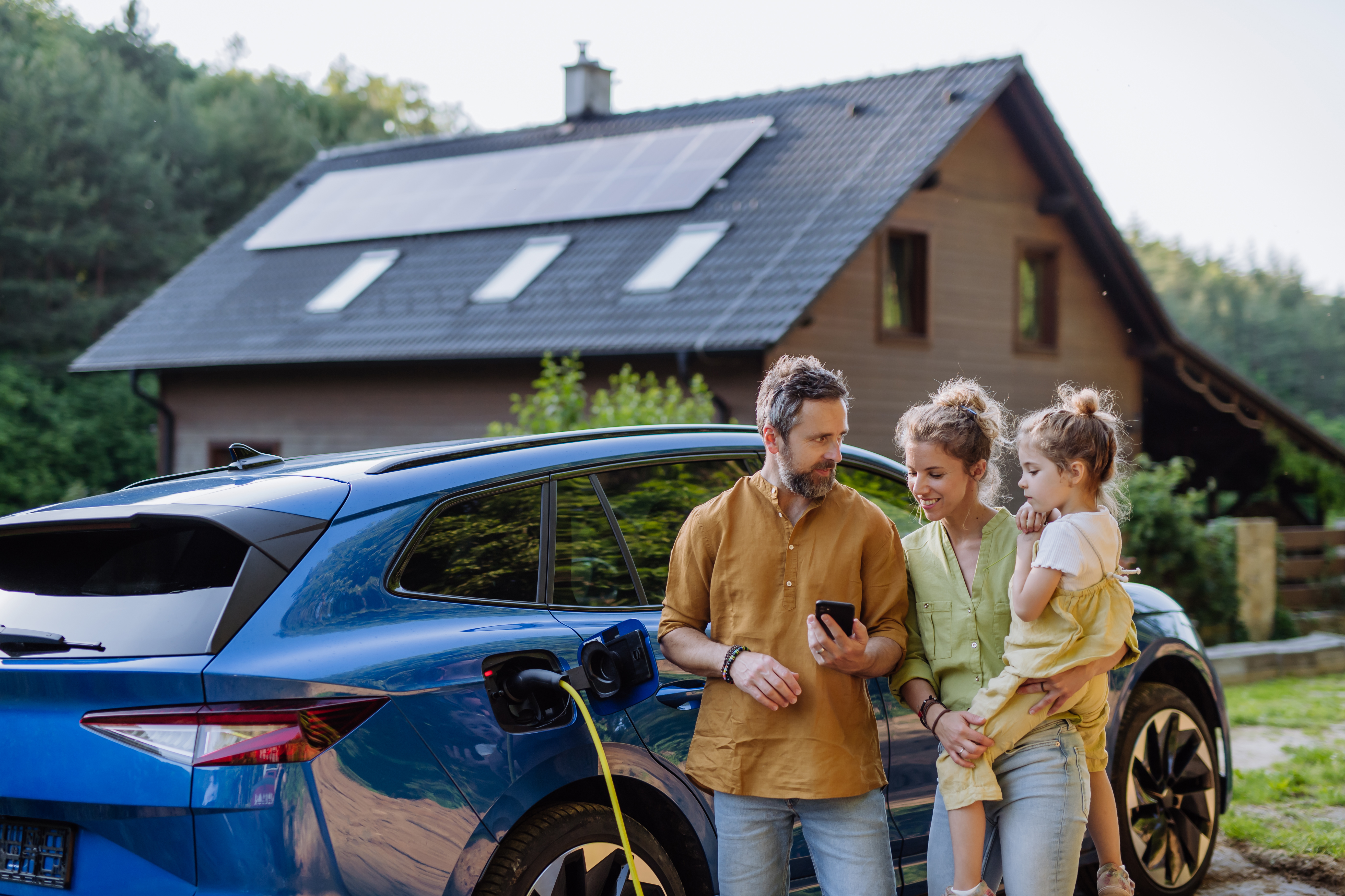 Distributed Intelligence - Family in front of EV and solar panel